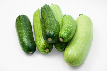 fresh zucchini on a white background. delicious green vegetables on the table. appetizing zucchini on a light texture. healthy food concept