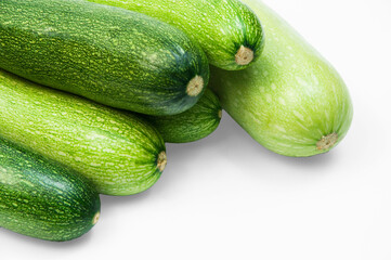 fresh zucchini on a white background. delicious green vegetables on the table. appetizing zucchini on a light texture. healthy food concept