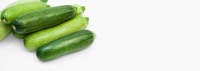 fresh zucchini on a white background. delicious green vegetables on the table. appetizing zucchini on a light texture. healthy food concept