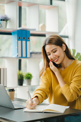 Asian business woman have the joy of talking on the phone, laptop and tablet on the office desk