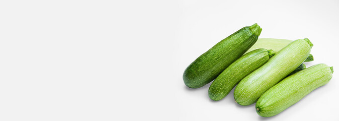 fresh zucchini on a white background. delicious green vegetables on the table. appetizing zucchini on a light texture. healthy food concept
