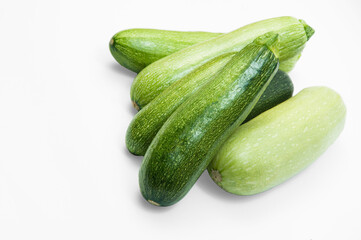fresh zucchini on a white background. delicious green vegetables on the table. appetizing zucchini on a light texture. healthy food concept