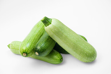 fresh zucchini on a white background. delicious green vegetables on the table. appetizing zucchini on a light texture. healthy food concept