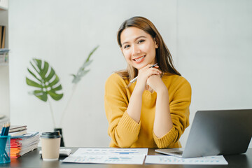 Asian business woman have the joy of talking on the phone, laptop and tablet on the office desk