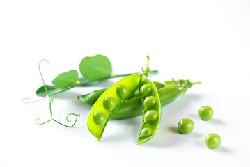 Pods of ripe green peas with leaves on a white background. Selective focus.