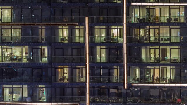 Flat night panorama of multicolor light in panoramic windows of multistory buildings aerial timelapse. Illuminated skyscraper in a big city