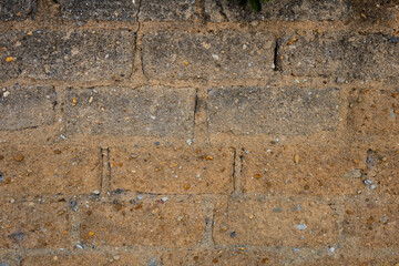 Clay wall background. Detail of old wall with roughly built bricks pattern and mixed pebbles. Texture of rough rustic wall with copy space. Materials and construction industry concept