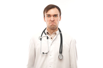 Fototapeta premium Portrait of angry doctor in white medical coat with stethoscope upset face screaming on white background with copy space