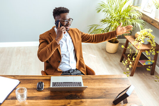 Angry stressed black male businessman disputing on phone with partner. Outraged african american manager, lawyer, banker, consultant or real estate agent listening bad news from client at office...