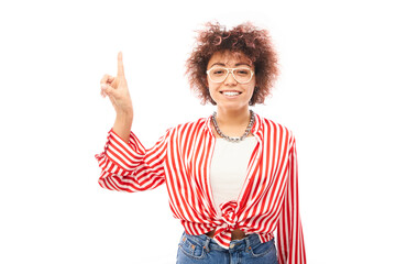Positive kazakh girl with afro hairstyle points forefinger at copy space isolated on white studio background