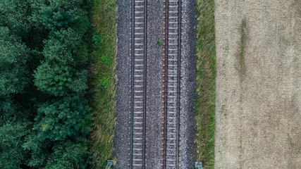 Küchenrückwand glas motiv Train tracks through German forest near Munich aerial drone view fotage © Pablo