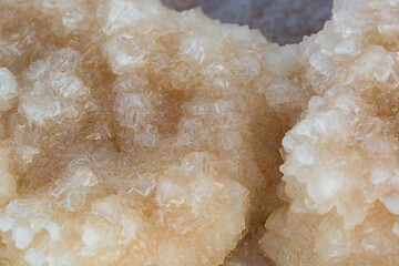 Big crystal of salt of Dead Sea, macro. The stones are covered with a crust of salt on the shores of the Dead-Sea, Ein Bokek beach, Israel. Extraction of salt. Salt on the seashore. Crystallization.