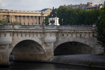 Obraz premium The Pont Neuf over the Seine River in the French city of Paris with beautiful monuments. Paris is divided by the Seine river and this beautiful European city is full of beautiful bridges.