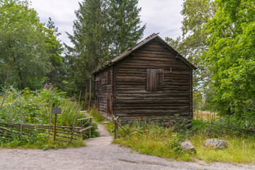 Fototapeta na wymiar Water mill 1700s log house in a park, a sunny summer day in Stockholm