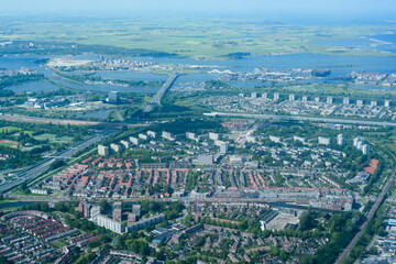 Fototapeta premium Aerial view from airplane of modern city with buildings, skyscrapers and highways between river. Amsterdam, Holland 