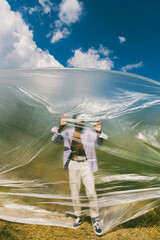 blurred african american man standing behind polyethylene under blue and cloudy sky