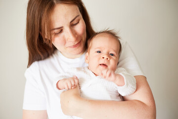 Mother holding her newborn baby. Home portrait of newborn baby and mother. Enjoying time together
