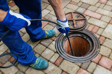 sewer cleaning service - worker clean a clogged drainage with hydro jetting - obrazy, fototapety, plakaty