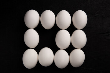 Chicken white eggs on a black background. Farm products. Natural eggs. Chicken eggs on the table