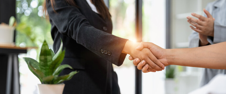 Millennial businessmen colleagues shaking hands on meeting in office, diverse enterpreneurs striking good deal, multiethnic teammates succeed in common project work