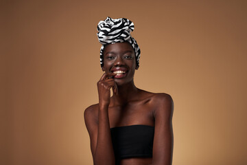 Smiling black girl wear turban look at camera