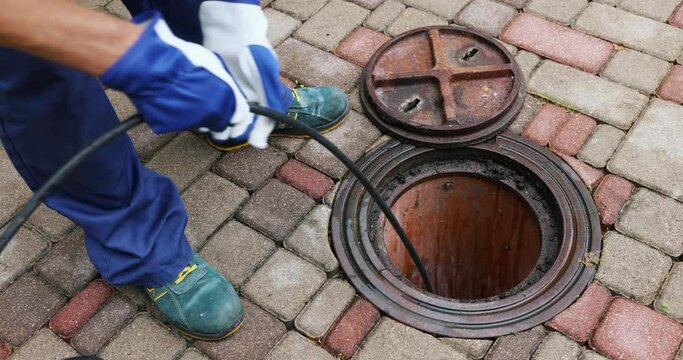 sewer cleaning service - worker clean a clogged drainage with hydro jetting