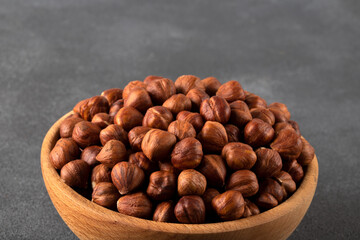 Top view of a bowl full of hazelnuts on dark background

