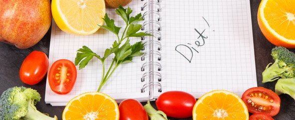 Notepad and fruits with vegetables containing natural vitamins and minerals, slimming and diet concept