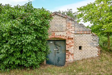 An old abandoned wine cellar on the edge of a vineyard.