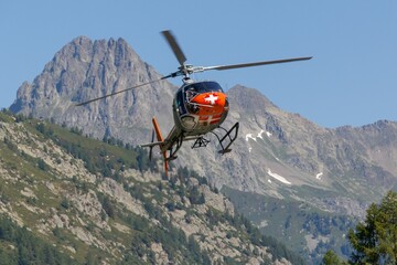 Chamonix Mont-Blanc Helicopter flying over dense trees and rocky mountains