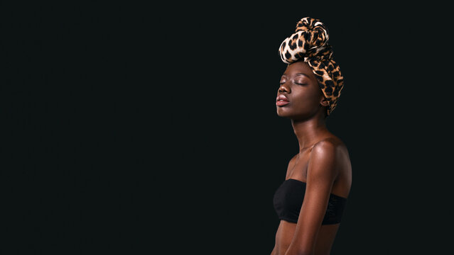 Side of dreamy black girl wearing african turban