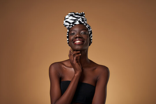 Black girl wearing african turban look at camera