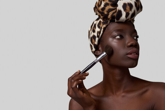 Cropped of focused black girl with cosmetic brush