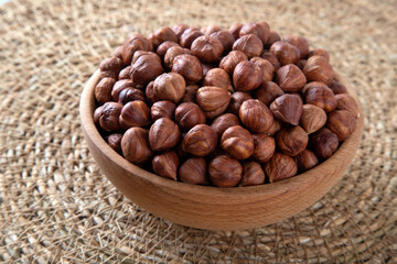 Bowl full of hazelnuts on wooden background
