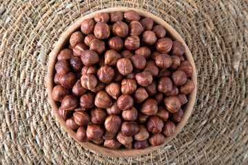 Bowl full of hazelnuts on wooden background
