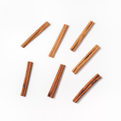 Arrangement of cinnamon sticks arranged randomly in the center in a flat lay. Minimalistic culinary concept from spices for cooking. Top view in square orientation.