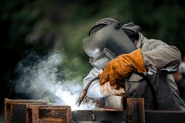 Man in a protective mask welding metal construction