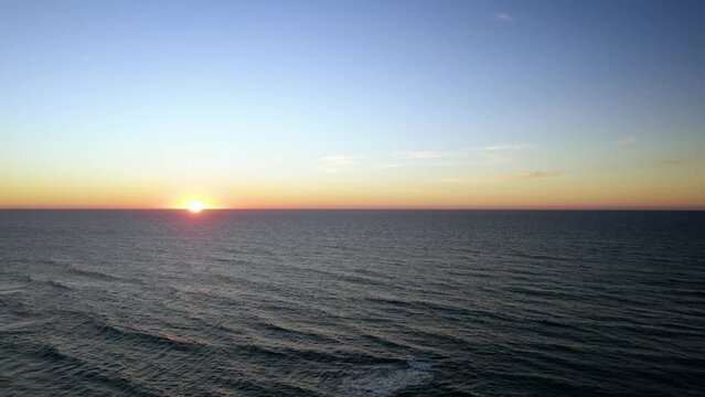 Drone shot of the sunset over the ocean in Praia Azul in Santra Cruz, Torres Vedras