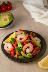 Shrimp cocktail salad with tomatoe, avocado, red onion and lemon.