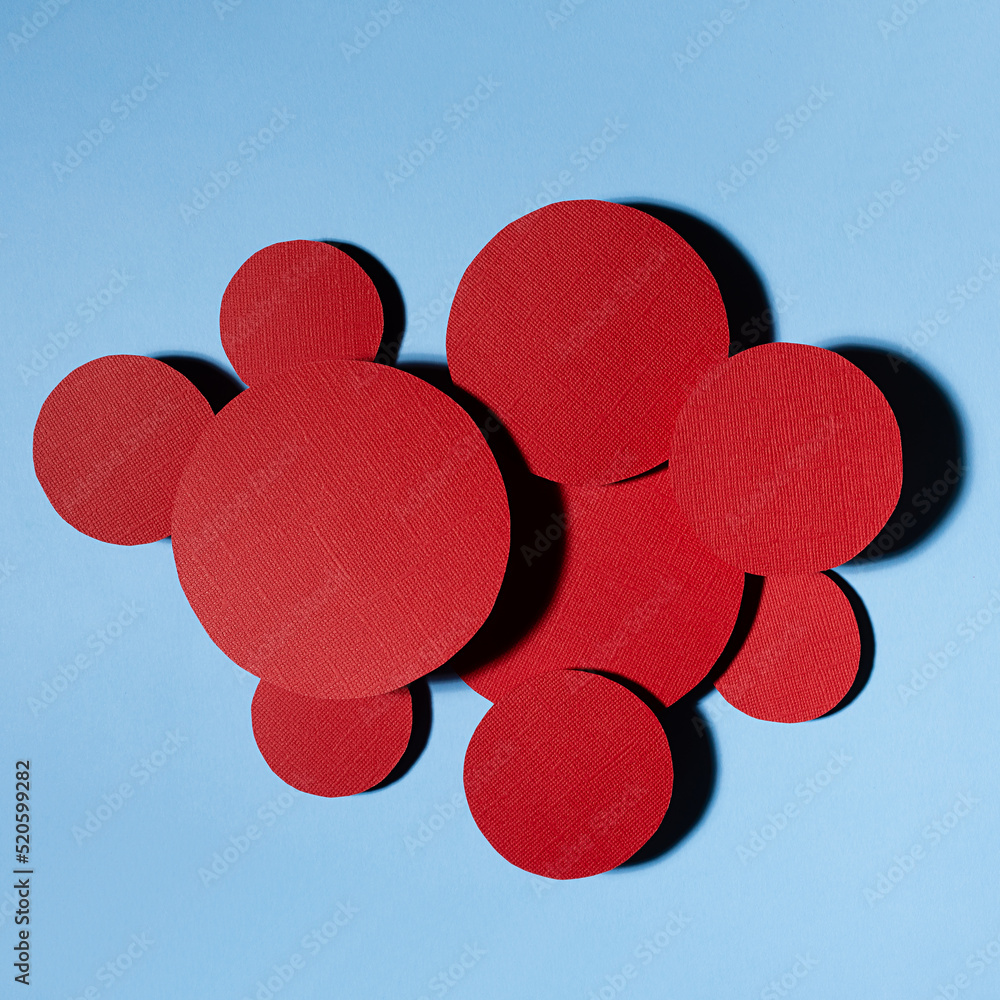 Poster different red circles soar as cluster on blue background in hard light with shadows, abstract colorf
