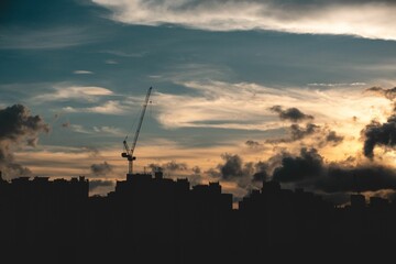Building silhouettes during a mesmerizing sunset with a cloudy sky above them
