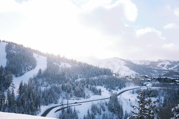 Aerial shot of snowy mountains in Park City Utah with bright sky