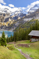 Fototapeta na wymiar Oeschinnensee, wooden chalet and Swiss Alps, Switzerland.