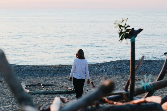 Back shot of a female walking in a beach against sea