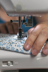 Close-up plan of woman's hands slipping a piece of dress fabric to perform her special embroidery. Woman seamstress doing home tailoring work.