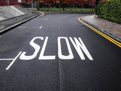 slow warning sign painted on the road