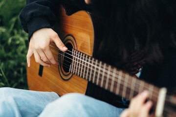 The girl's hands play the guitar