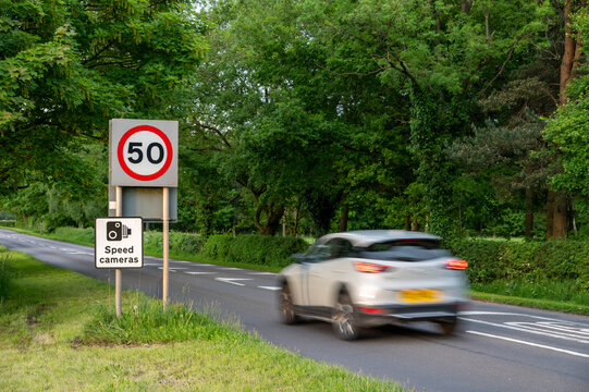 Vehicle travelling towards 50mph and speed camera signs on a Cheshire road, Cheshire, England, United Kingdom