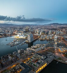 Aerial shot of Oslo, with lots of buildings and lights, surrounded by sea, Norway - obrazy, fototapety, plakaty