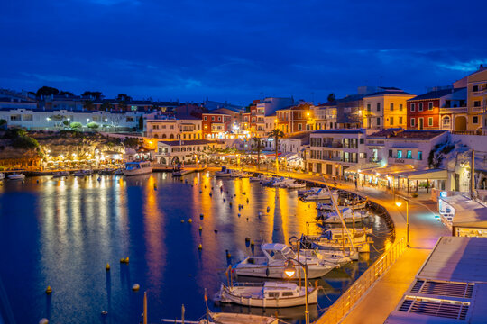 View of cafes, restaurants and boats in harbour at dusk, Cales Fonts, Es Castell, Menorca, Balearic Islands, Spain